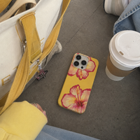 KASED Mimosa iPhone case – yellow tropical floral print, shown on iPhone
