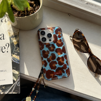 KASED Exotic Cleo iPhone case – blue leopard print, shown on iPhone